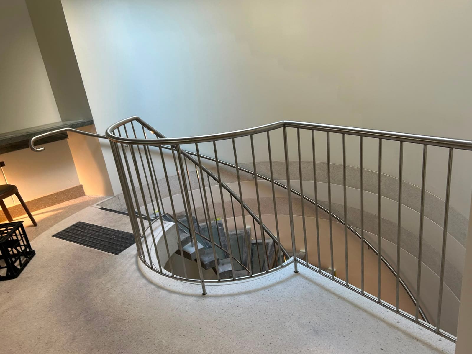 Curved stainless balustrade with vertical rods around stair void
