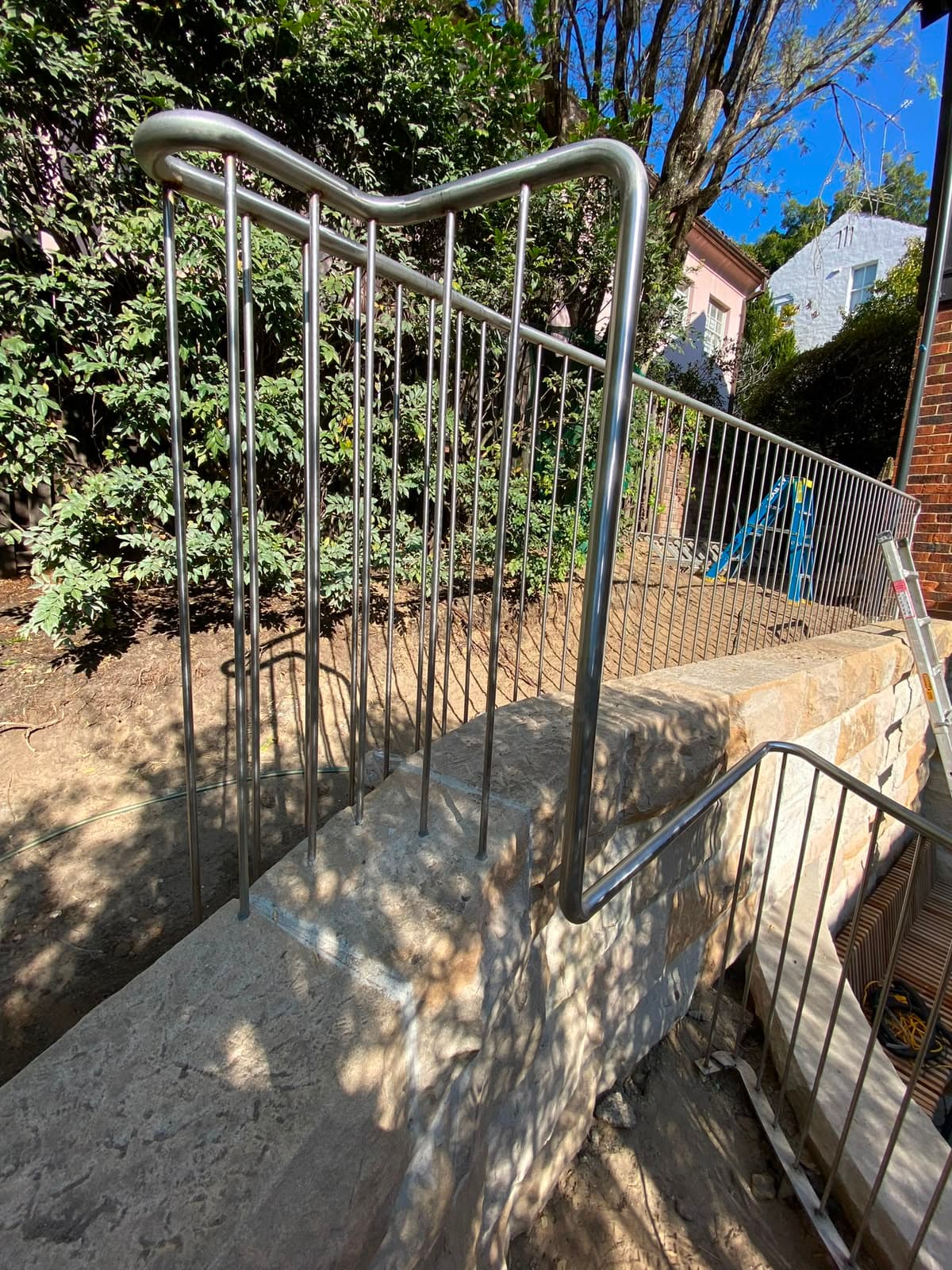 Stainless rod balustrade on sandstone wall with stepped handrail